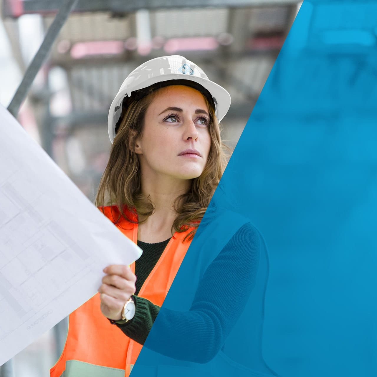 A female engineer, architect or construction worker, looking at plans wearing a high vis vet and hard hat