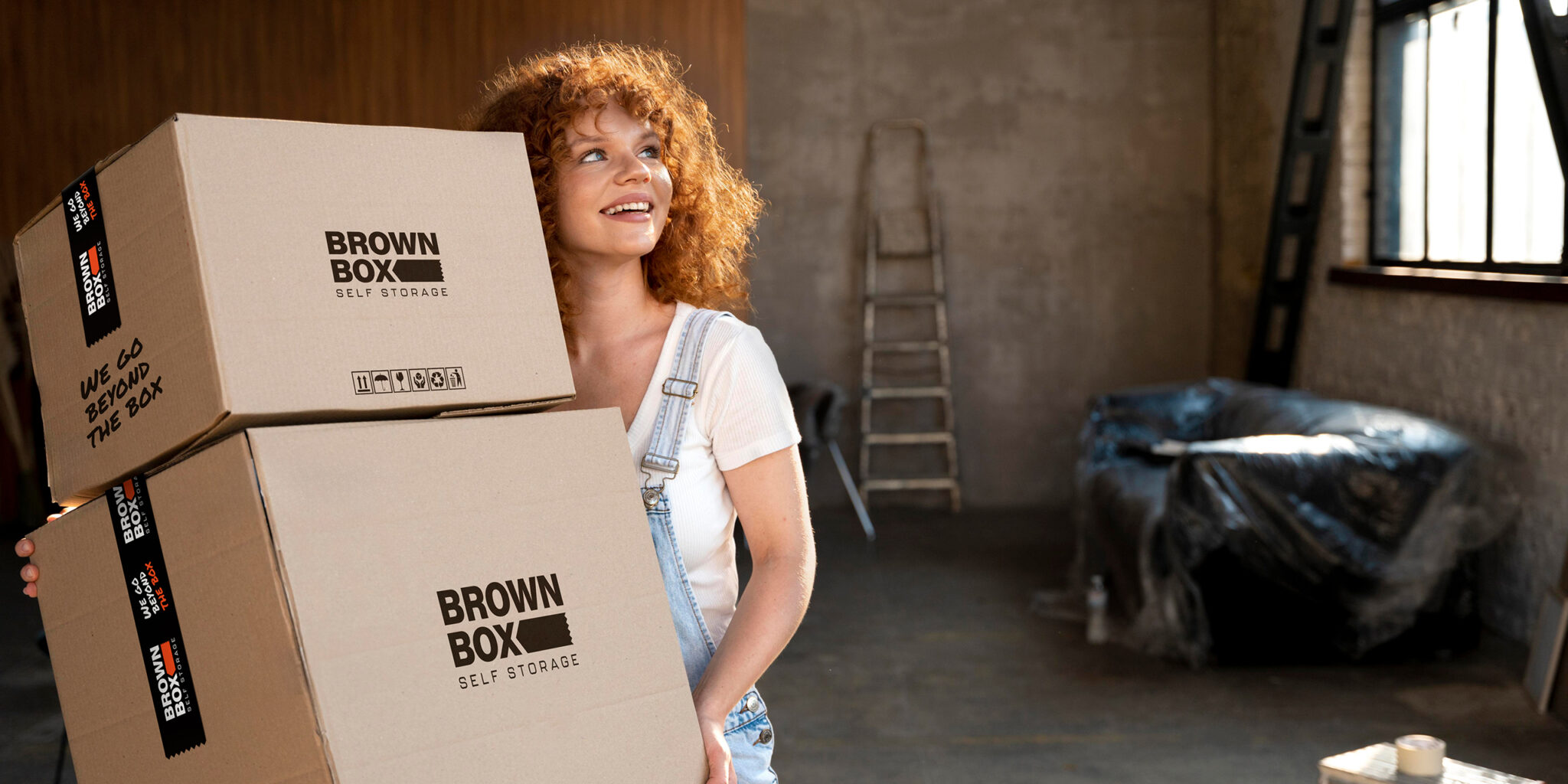 Woman carrying brown cardboard boxes Woman carrying brown cardboard boxes as she is starting a renovation project.