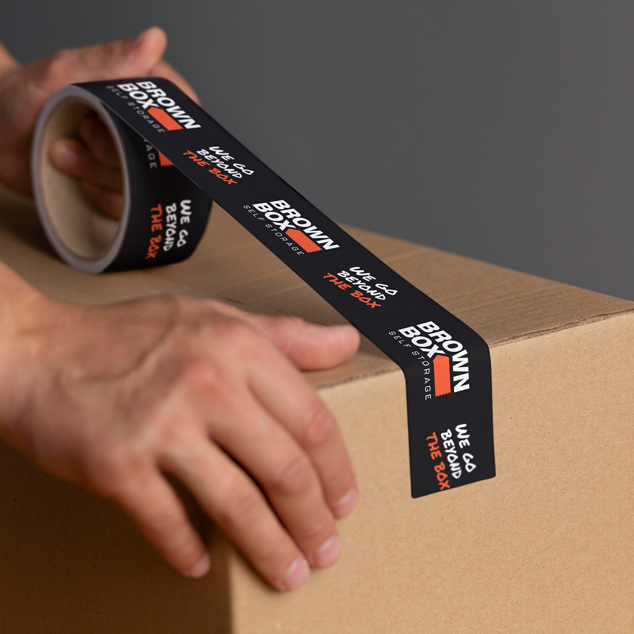 Brown box storage branded tape Brown box storage branded tape being applied to a cardboard box.